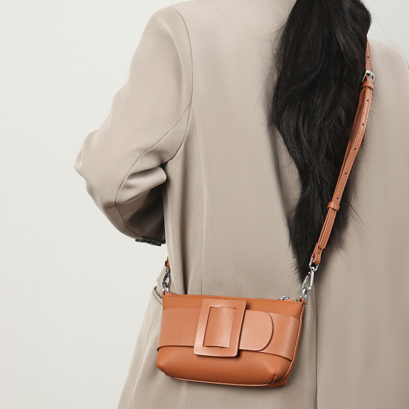 Women’s Genuine Leather Decorative Buckle Zipper Crossbody Baguette Bag in brown color lifestyle model wearing it as a crossbody bag
