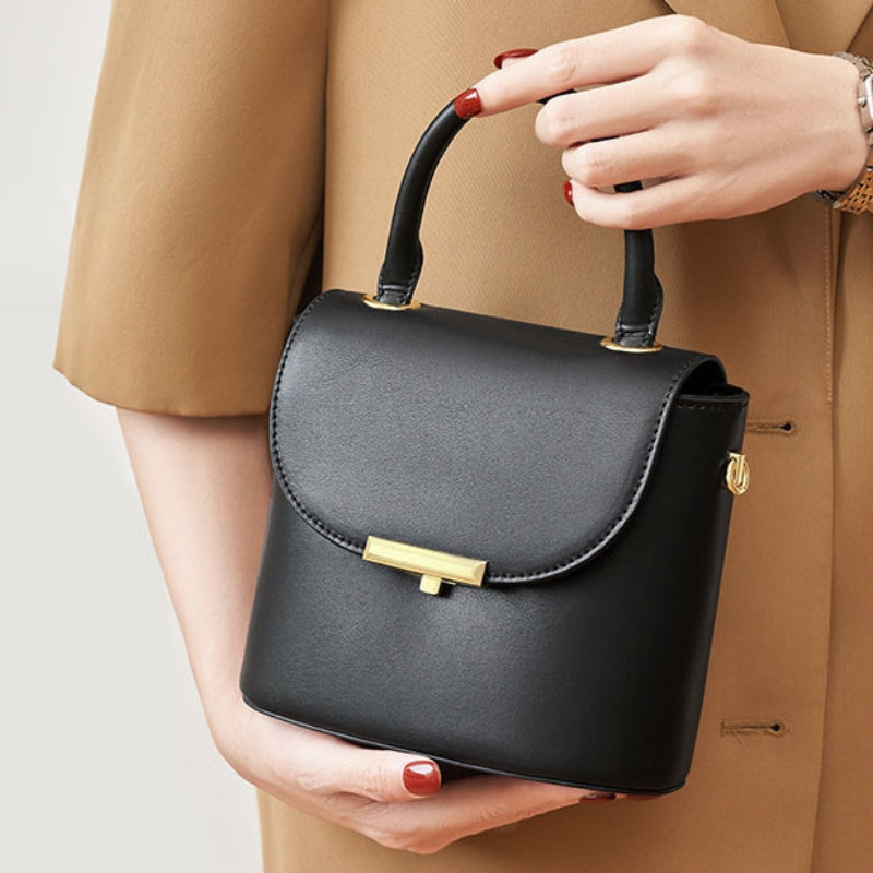 Women’s Minimalist Genuine Leather Lock Buckle Crossbody Shoulder Handbags lifestyle in black color  model handling it as a top handle bag