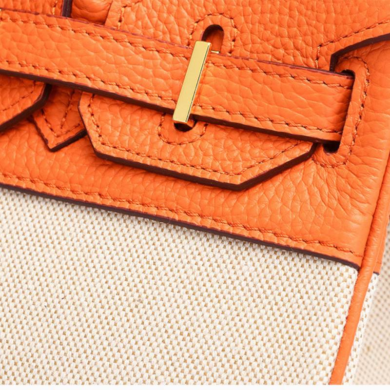 Base of structured leather canvas handbag with protective metal feet