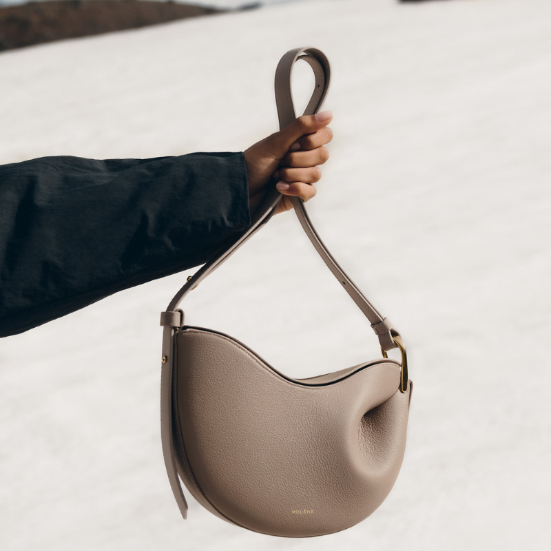 Beige leather crescent shoulder bag with minimalist curved silhouette