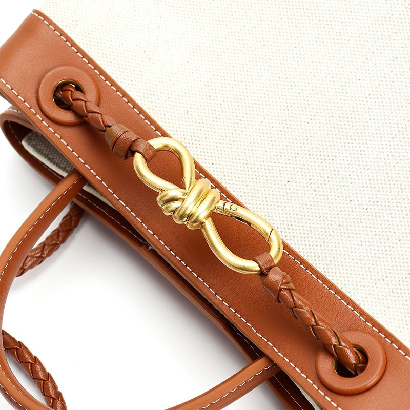 Gold hardware detail on leather canvas handbag