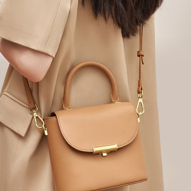 Golden brown lock buckle handbag with top handle and adjustable shoulder strap