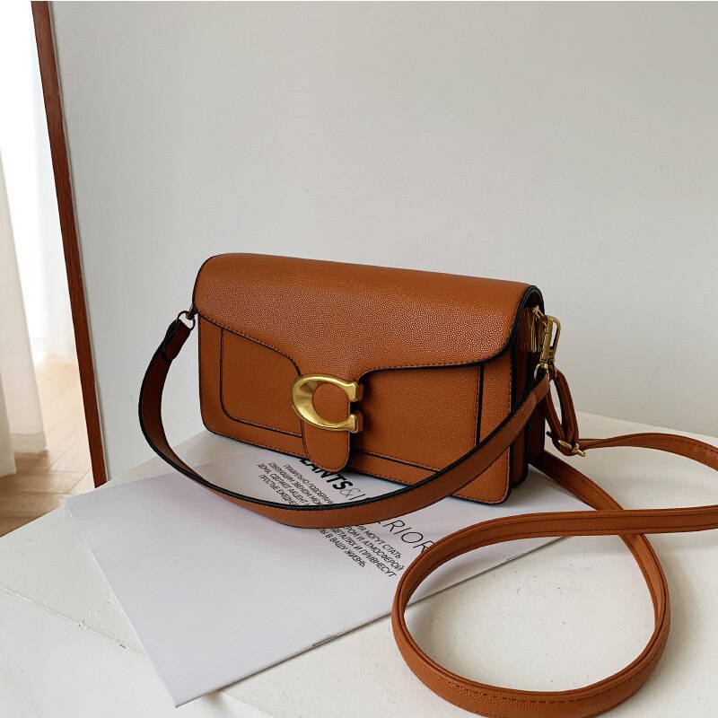 Leather Shoulder Crossbody Bag held by model in caramel color lifestyle