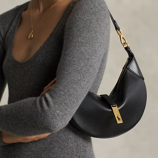 Saddle Half Moon Shoulder Bag in Genuine Calfskin Leather in black color held by model as a shoulder bag