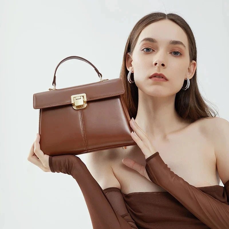 Top Handle Crossbody Genuine Leather Bag with Lock Closure in dark brown color held by model