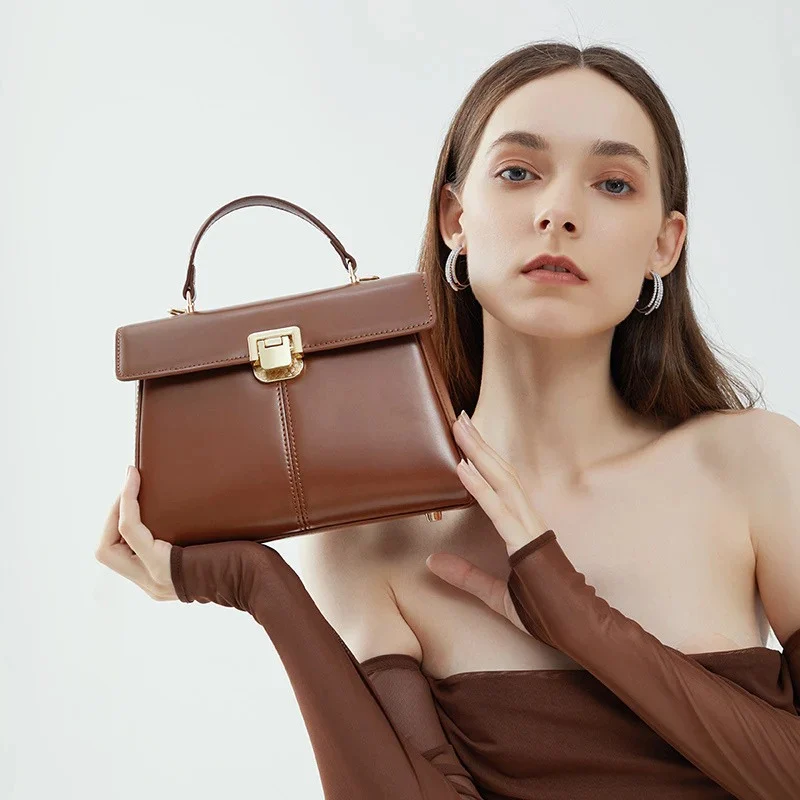 Top Handle Crossbody Genuine Leather Bag with Lock Closure in dark brown color held by model