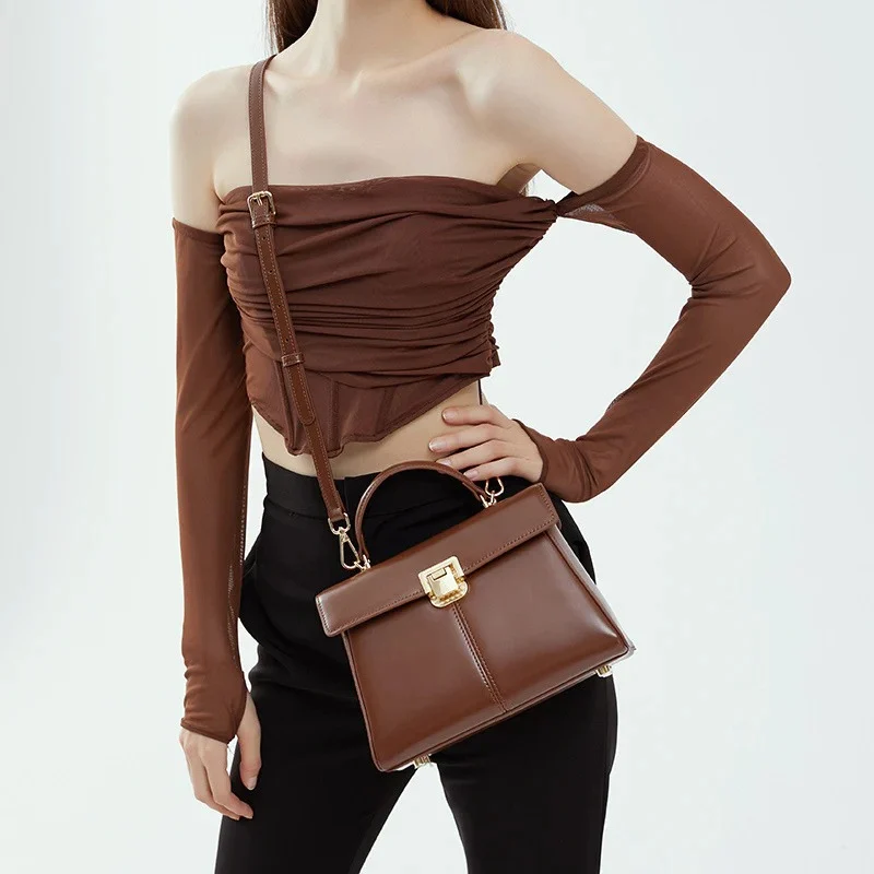 Top Handle Crossbody Genuine Leather Bag with Lock Closure in dark brown color lifestyle holding by model as a crossbody bag