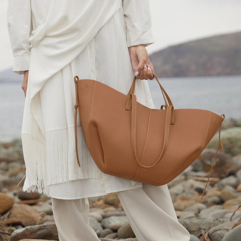 Women carrying a soft leather tote shoulder bag outdoors