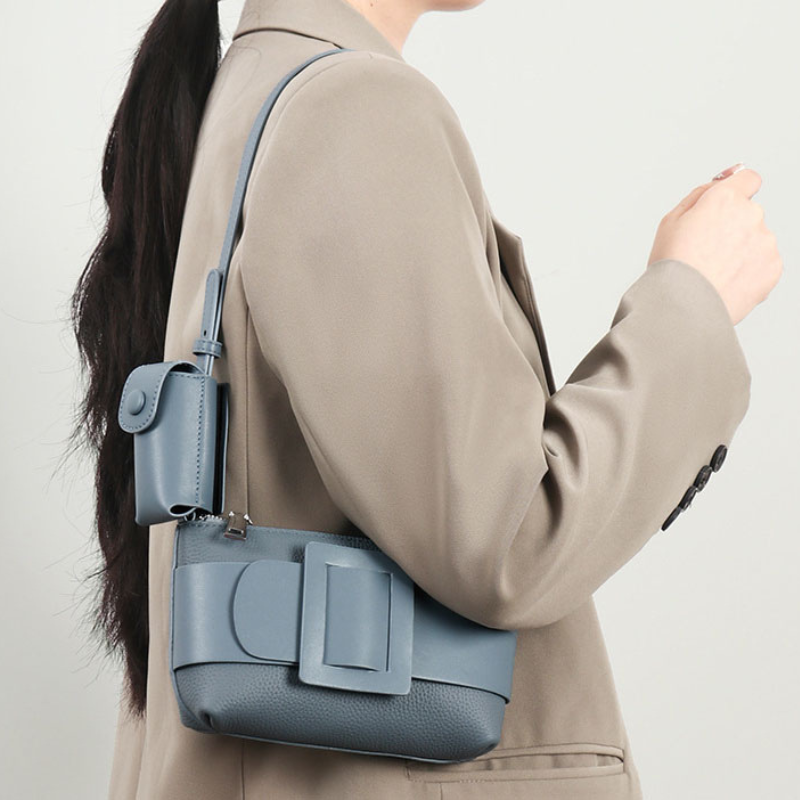 Women’s Genuine Leather Decorative Buckle Zipper Crossbody Baguette Bag in mint blue color lifestyle model wearing it as a shoulder bag