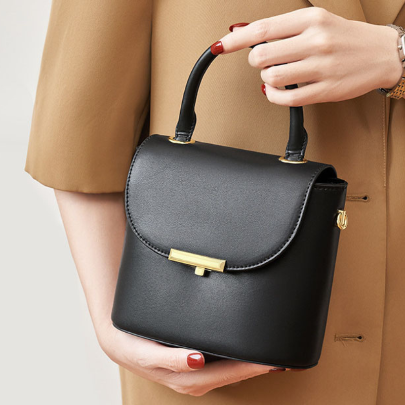 Women’s Minimalist Genuine Leather Lock Buckle Crossbody Shoulder Handbags lifestyle in black color  model handling it as a top handle bag