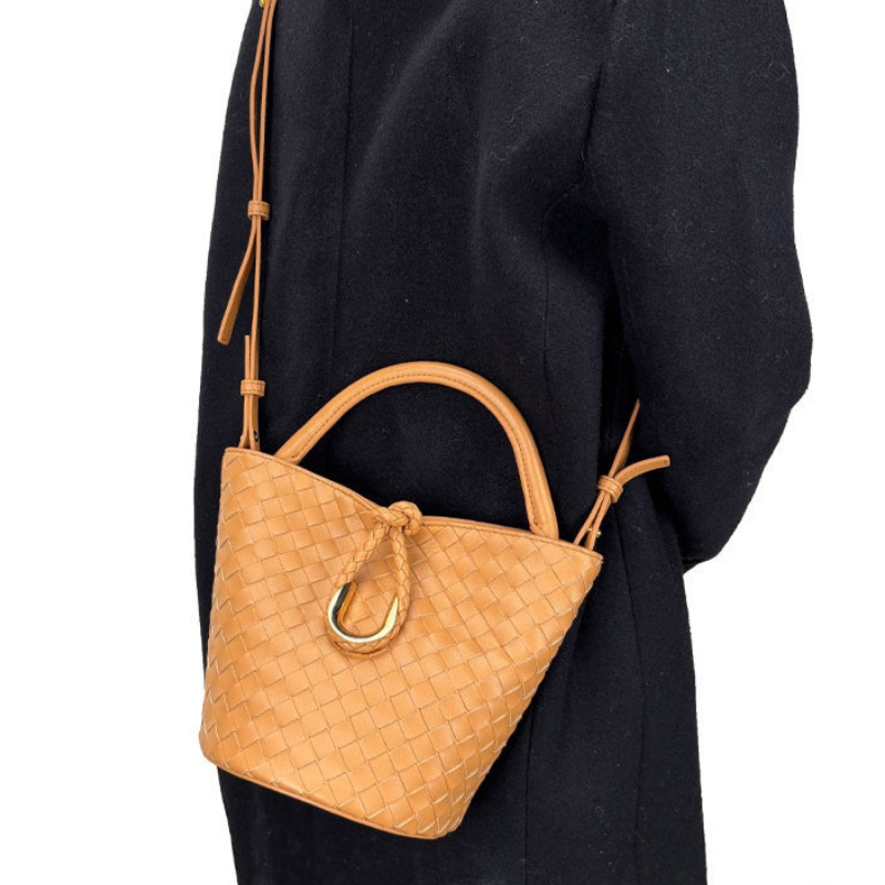 Woven leather bucket bag in camel — worn crossbody, lifestyle view