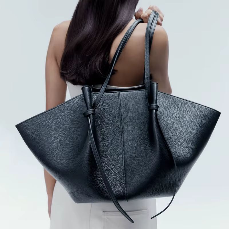 black slouchy leather tote bag worn on shoulder large soft everyday bag