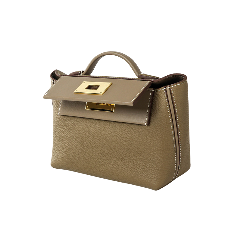 elegant minimalist leather handbag with top handle and gold lock closure side angle