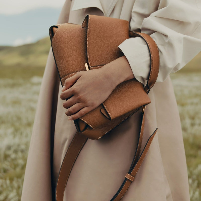fold over leather bag worn over shoulder with minimalist outfit