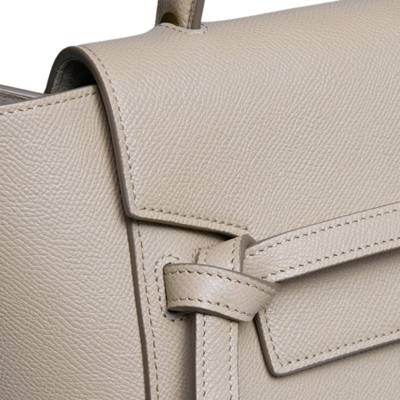 genuine leather satchel bag detail top handle flap closure texture close up