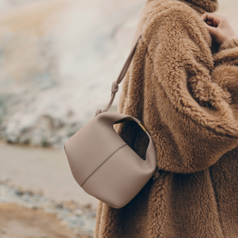 leather dumpling crossbody bag worn outdoors with casual outfit
