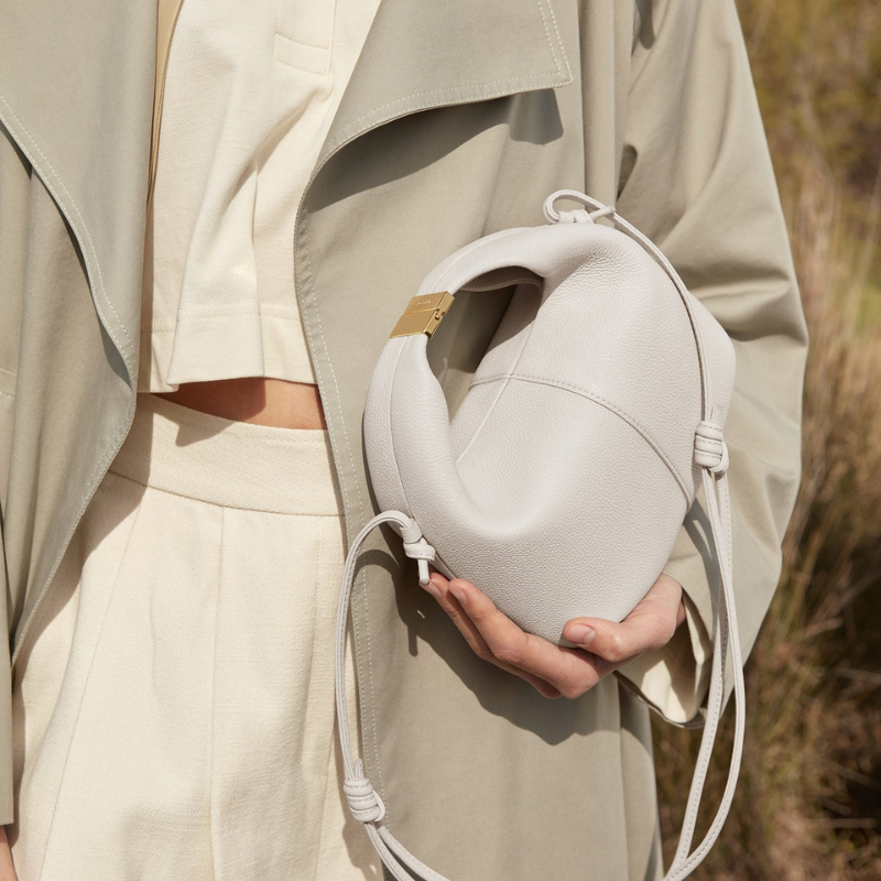 leather dumpling crossbody bag worn with neutral outfit modern style