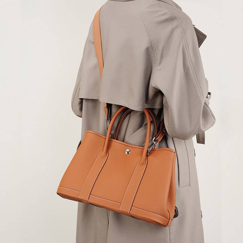 leather tote bag with crossbody strap for women worn crossbody in daily setting