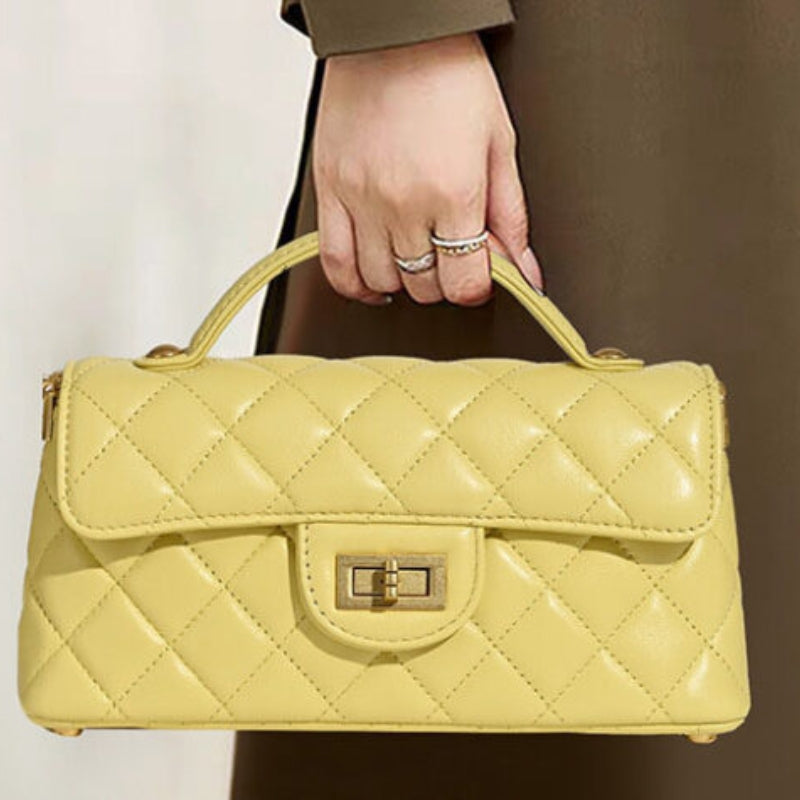 quilted lambskin crossbody bag carried by hand with top handle and gold lock