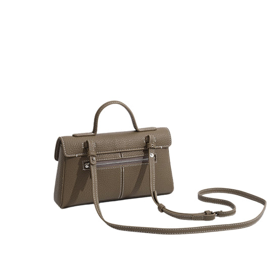 side view of compact leather flap handbag with top handle and crossbody strap
