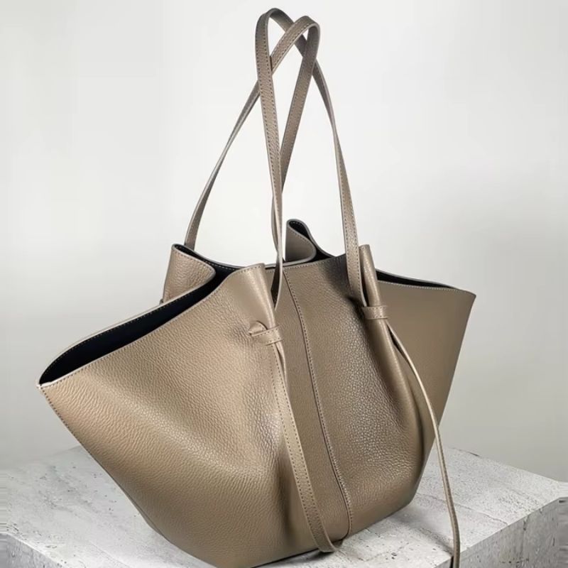 slouchy leather tote bag beige side view with soft structure and wide shape