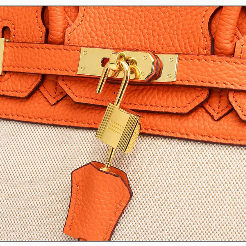 structured top handle bag orange angled view with gold hardware
