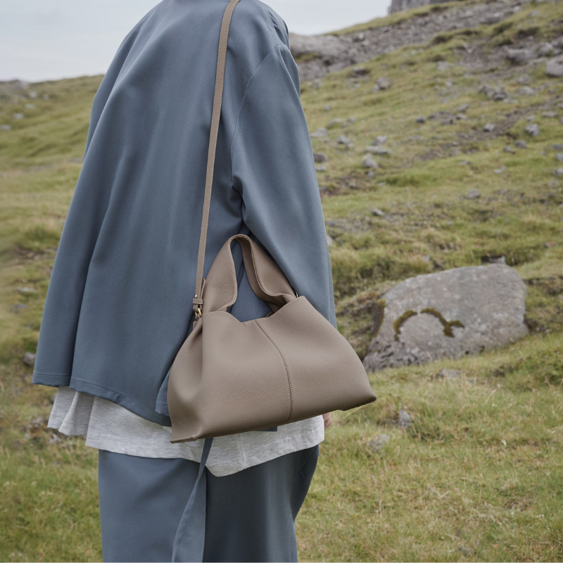 top handle shoulder bag worn crossbody with casual outfit outdoors
